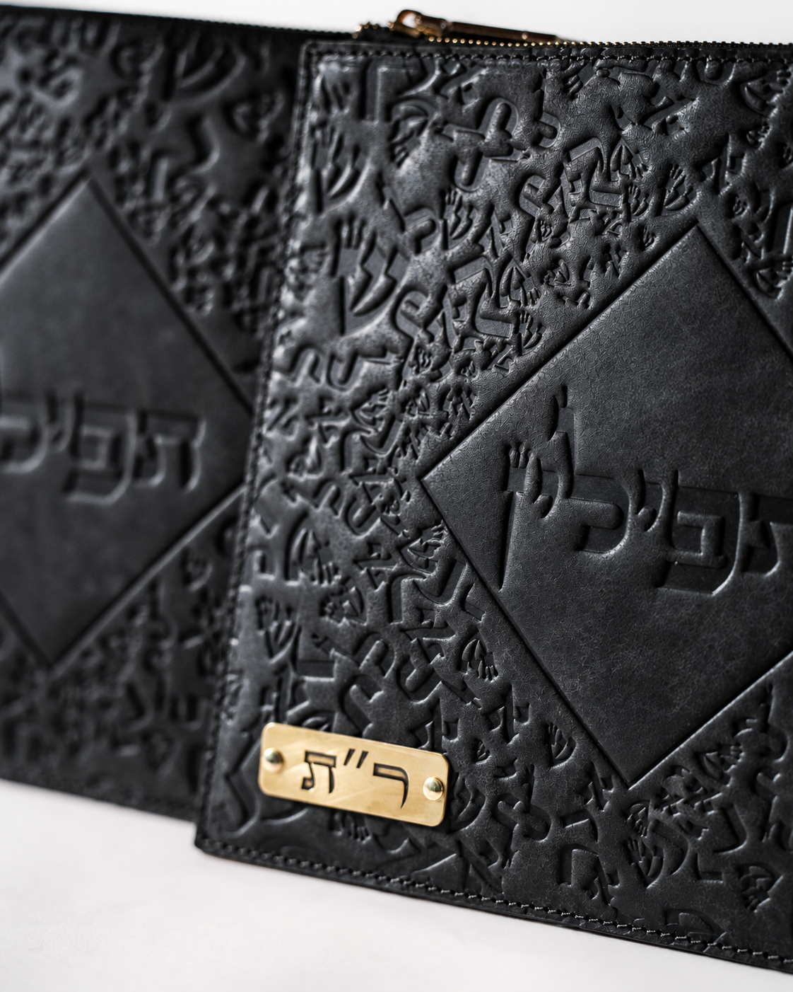 Close-up of embossed Israel Letters on black leather with a brass plate