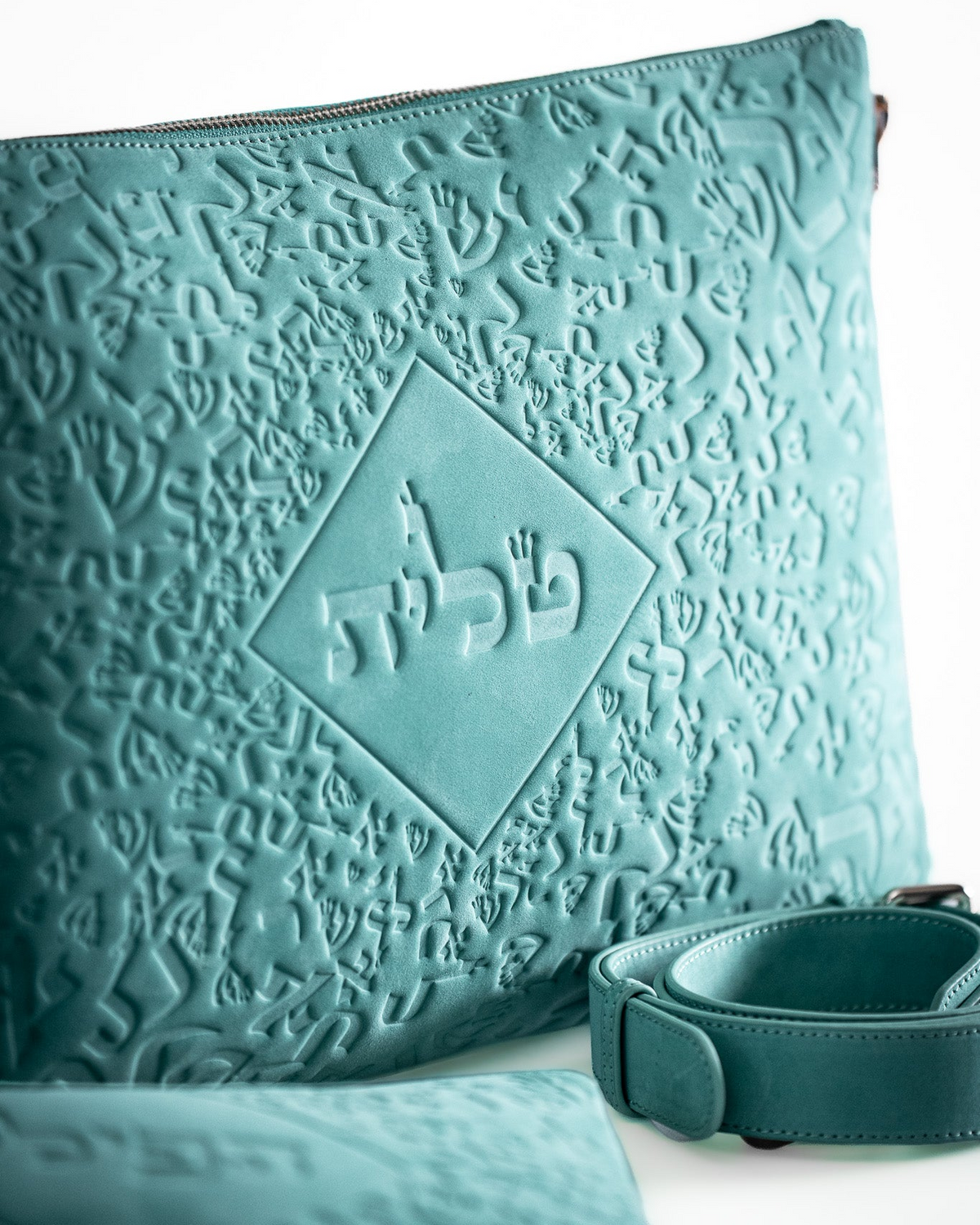 Close-up of the embossed turquoise leather tallit bag with a dark strap