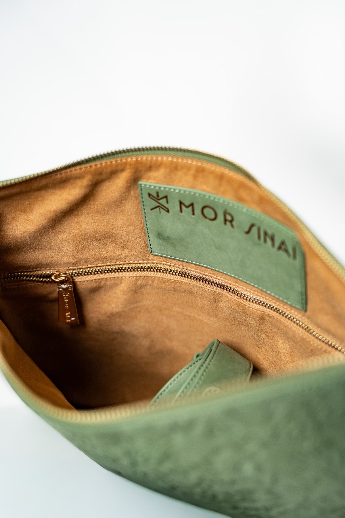 Inside of a green leather tallit bag showing the tan lining