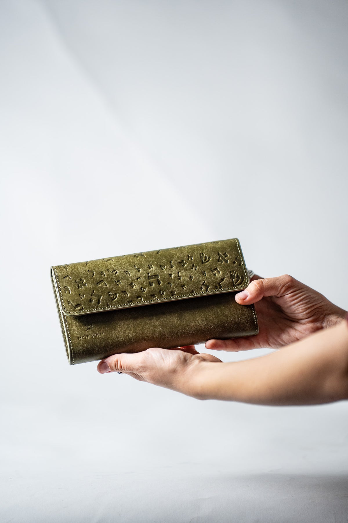 Green leather ladies wallet resting on a hand