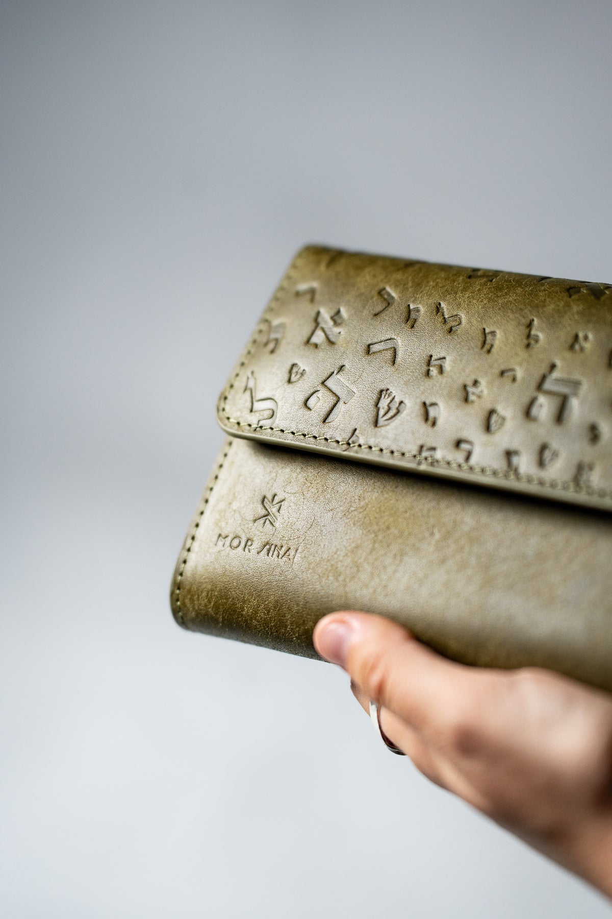 Green embossed leather ladies wallet held in a hand
