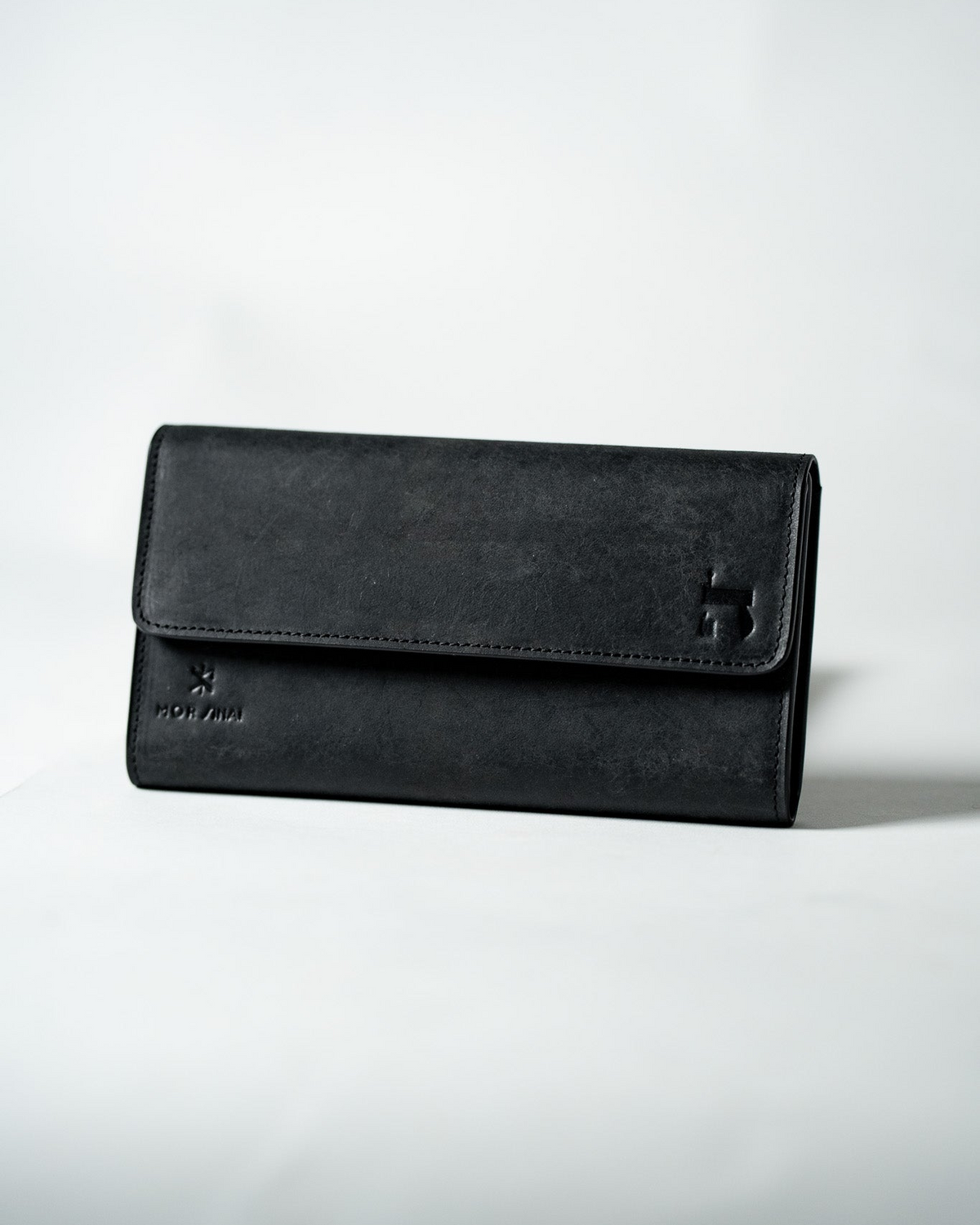 Black leather ladies wallet closed on a white background