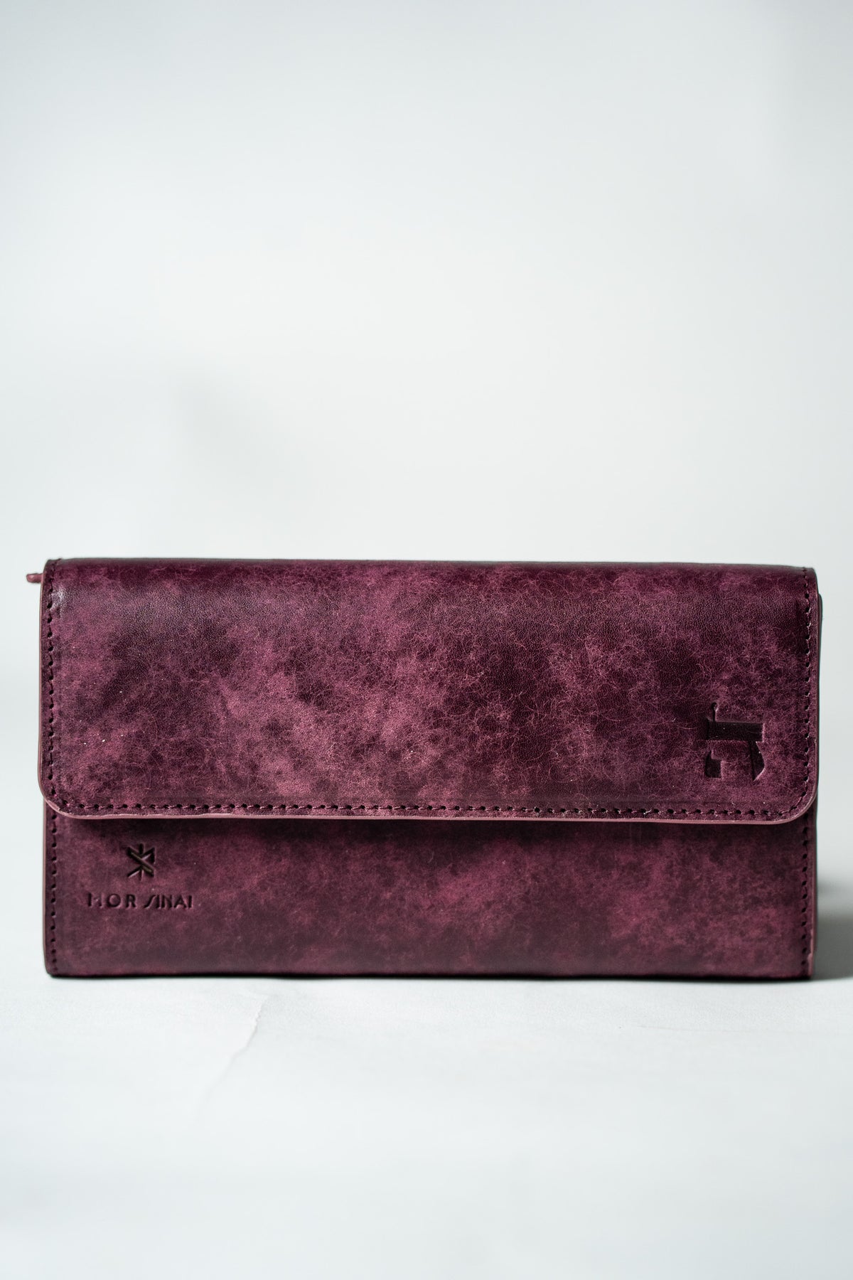 Burgundy leather ladies wallet closed on a white background