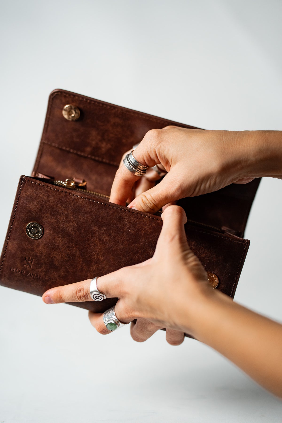 Hands opening the brown embossed leather ladies wallet