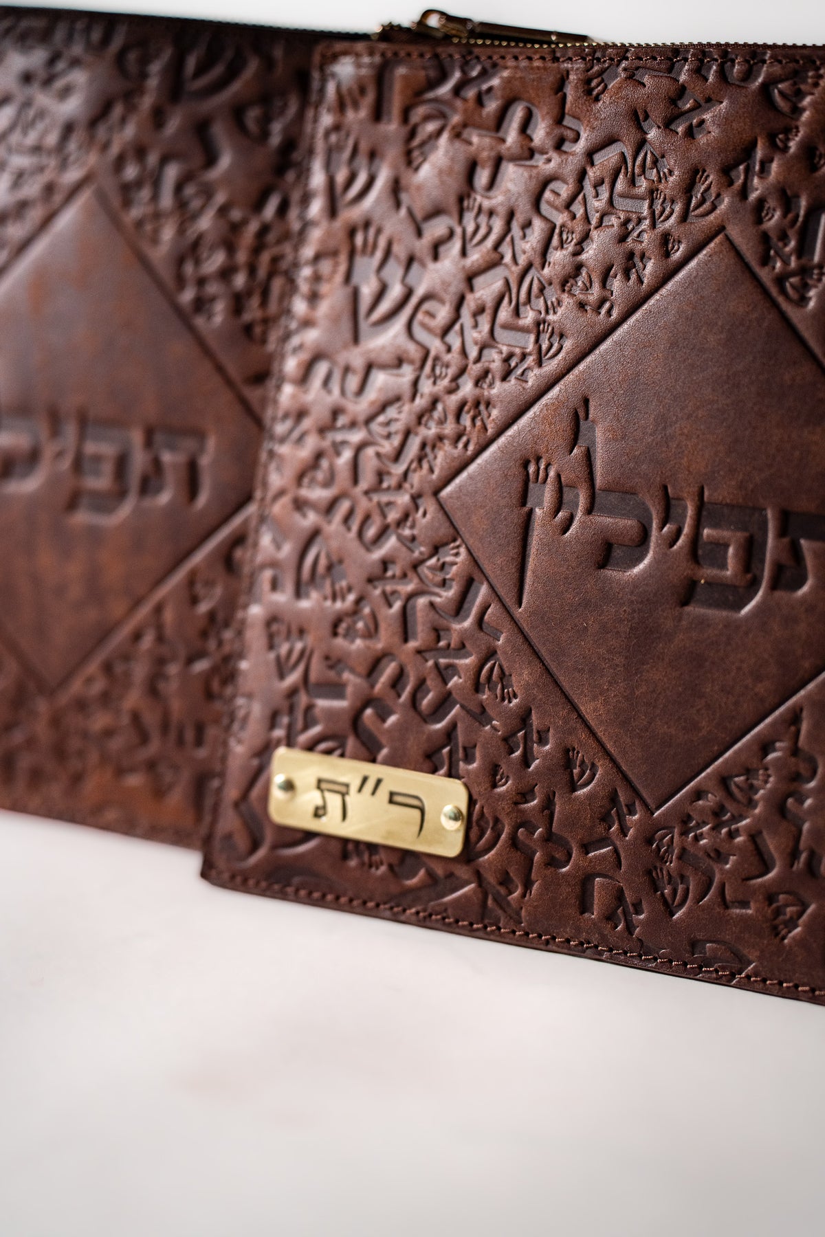 Close-up of the brass plate and embossing on the brown Chabad bag