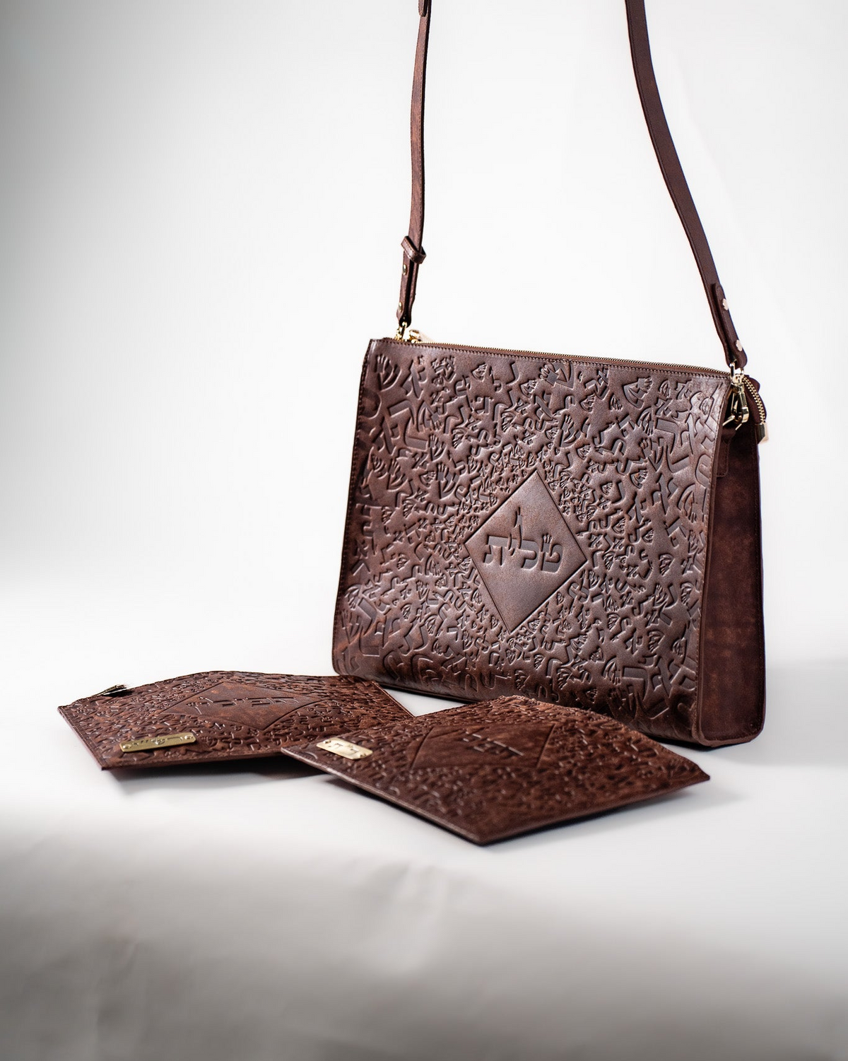 Brown Chabad leather tallit bag with a tefillin bag, hanging by its strap