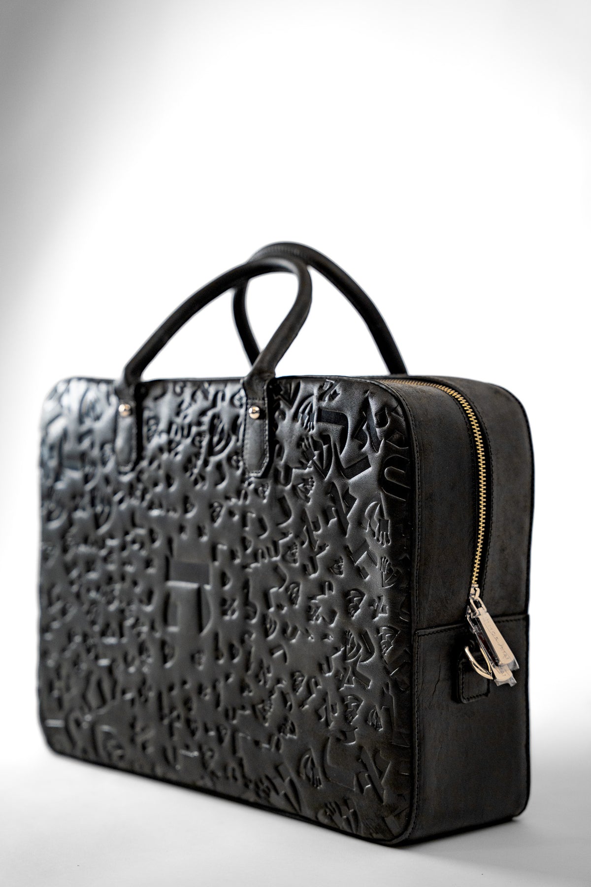 Black embossed leather laptop bag standing upright